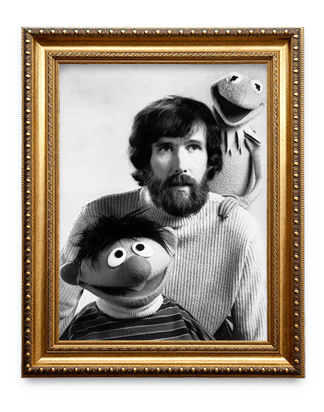 A golden frame with a Black and White image of Jim Henson